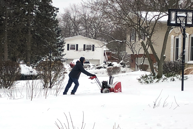 Man uses walk behind snow plow